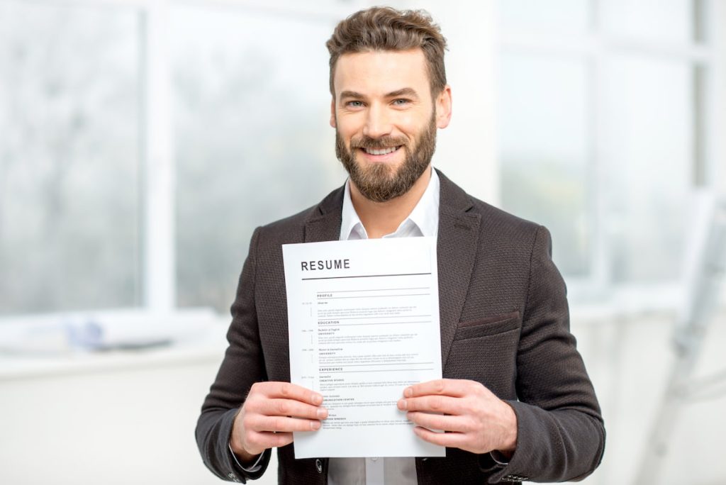 A man in a suit holding a resume