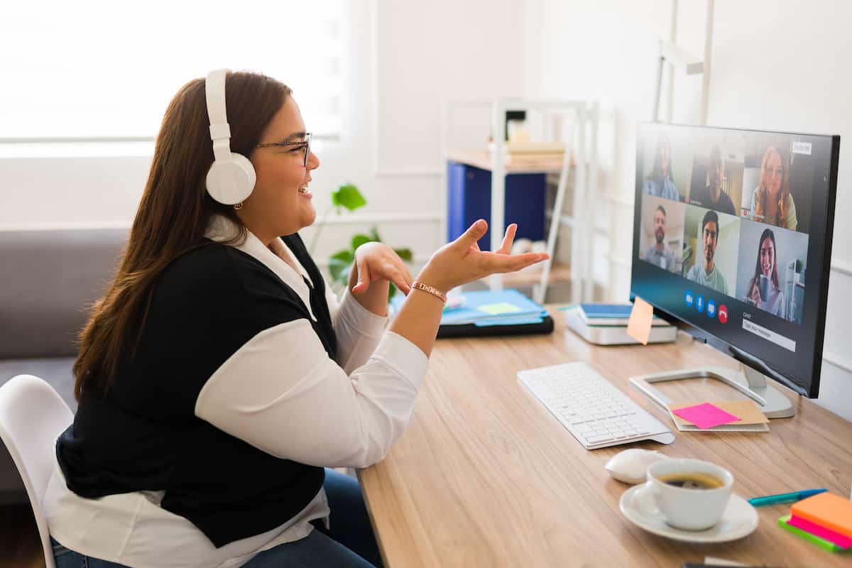 An agent sitting at her computer in a virtual meeting