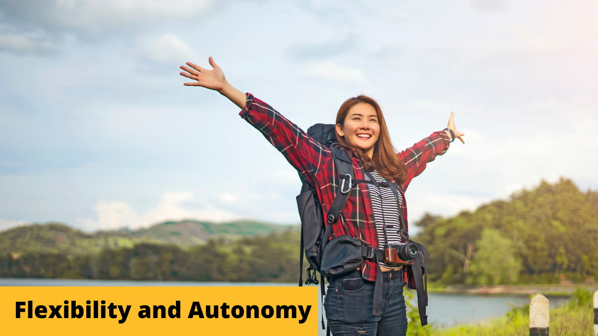 Woman with a large backpack near a lake with arms stretched out