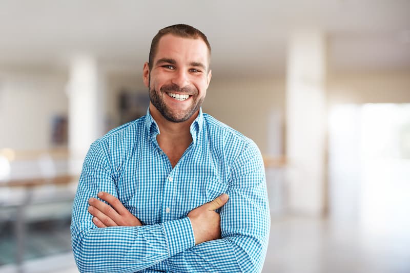 Young Insurance agent posing for picture with his arms crossed and smiling