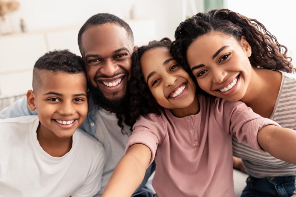 A family huddled together and smiling for a picture