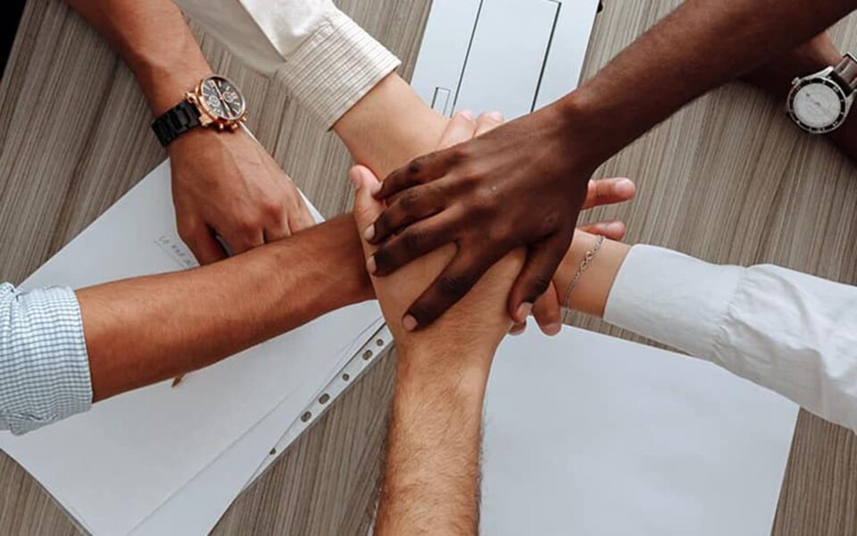 Multiple hands huddled together in a stack