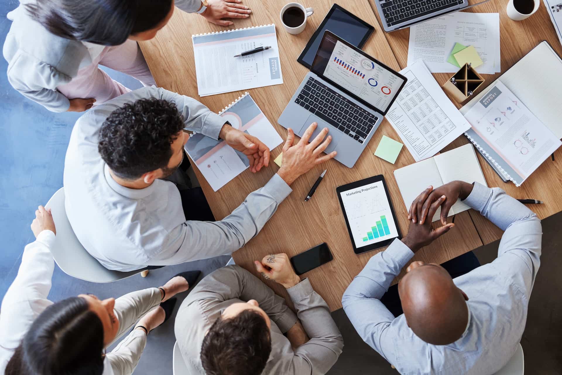 An overhead view of a group of agents gathered at a desk working on paperwork