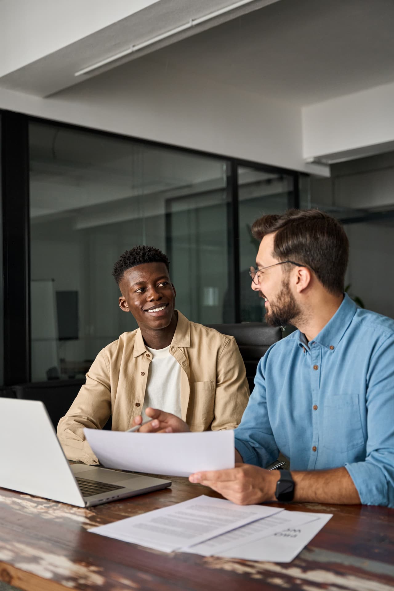 Two busy happy employees checking documents talking in office.